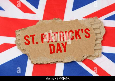 Feiertage in Großbritannien. Vor dem Hintergrund der britischen Flagge liegt Pappe mit der Inschrift St. Tag Der Patricks Stockfoto