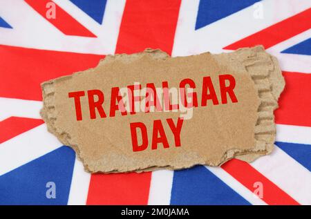 Feiertage in Großbritannien. Vor dem Hintergrund der britischen Flagge liegt Pappe mit der Inschrift Trafalgar Day Stockfoto