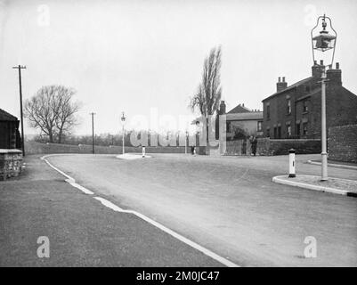 Schwarzweißfoto aus dem frühen 20.. Jahrhundert mit Nottingham Road in Codnor, Derbyshire, England, mit alten Häusern und neuer Straße am Ende von Daykin's Row. Stockfoto