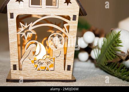 Geburtsszene auf einem Hügel im Schnee. Joseph von Nazareth zündet die Laterne an und Maria pflegt ihr Baby Jesus. Stockfoto