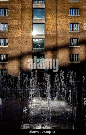 Die St. Martins School of Design ist durch die herrlichen Brunnen zu sehen, die in der scharfen Wintersonne glitzern. Die Schatten auf dem Gebäude sind dramatisch Stockfoto