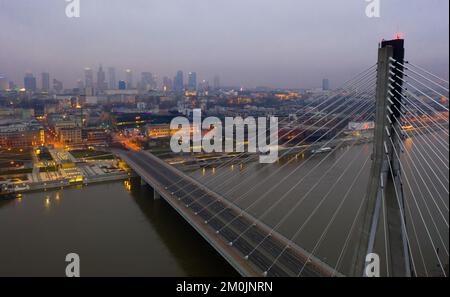 Warschau auf der Weichsel mit der Swietokrzyski-Brücke am Abend Stockfoto