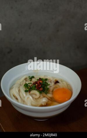 Mishima udon ist exquisit in ihrer Einfachheit. Serviert wird warm oder kalt, nur mit Sojasoße, grünen Zwiebeln, einem Hauch Chili und frischen Eiern beim Kunden Stockfoto