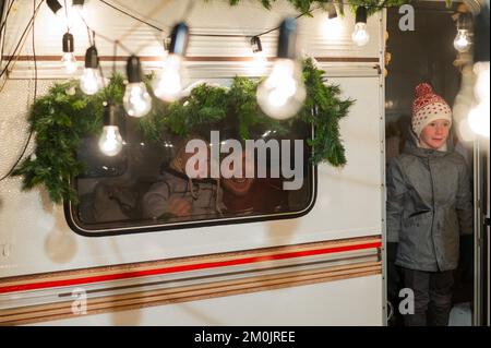 Vater und zwei Söhne feiern Weihnachten in einem Van. Stockfoto