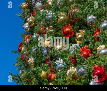 Nahaufnahme eines dekorierten Weihnachtsbaums mit Gold-, Silber- und gelben Kugeln. Stockfoto