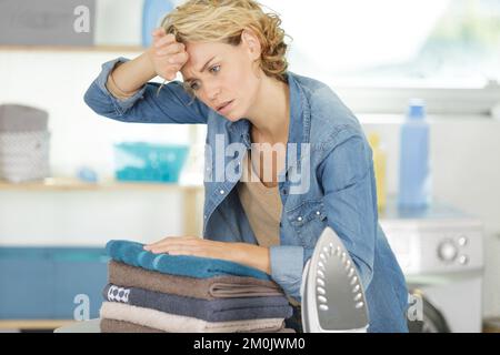 Müde Frau auf dem Bügelbrett Stockfoto