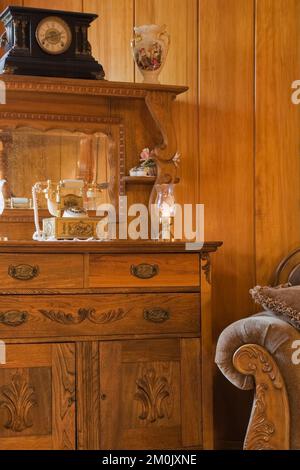 Antike Holzkommode mit Vintage-Objekten im Wohnzimmer im alten Haus um 1834 dekoriert. Stockfoto