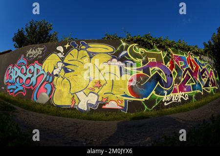Farbenfroher Hintergrund der Graffiti-Malerei mit hellen Aerosolstreifen an der Metallwand. Alte Straßenkunst aus Spraydosen. Zeitgenössische Jugendkultur im Hintergrund Stockfoto