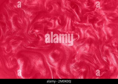 Roter Hintergrund. Bewegung der rosa glänzenden Flüssigkeit. Farbe des Jahres 2023 Viva Magenta. Wellen auf einer glitzernden Flüssigkeit. Stockfoto