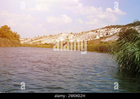 Antike multimillionäre Kreideberge auf der Steppenoberfläche der Erde. Weiße Kreideberge in einer Landschaft mit Fluss und grünen Bäumen Stockfoto