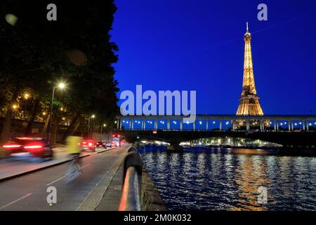 Eiffelturm bei Nacht mit Verkehr auf der Zufahrt am Flussufer und Pont de Bir-Hakeim Brücke über die seine im Vordergrund. Paris. Frankreich Stockfoto