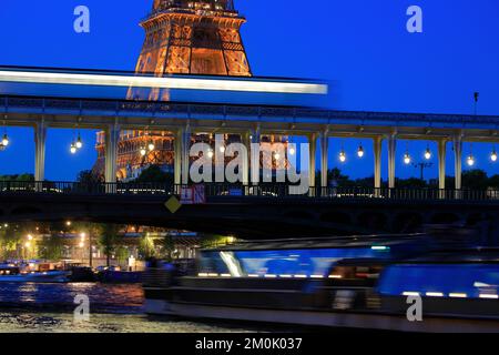 Ein geschlossener Blick auf den Eiffelturm bei Nacht mit einer U-Bahn durch die Brücke Pont de Bir-Hakeim über die seine im Vordergrund. Paris. Frankreich Stockfoto