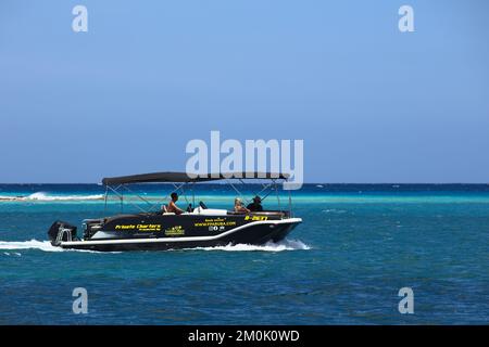 ORANJESTAD, ARUBA - 02. JUNI 2022: Kleine private Chartermotorboote, die entlang des Surfside Beach in Oranjestad auf der karibischen Insel Aruba fahren Stockfoto