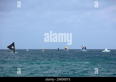 ORANJESTAD, ARUBA - 27. MÄRZ 2022: Kleine Sonnenfisch- und Laserboote, die am Surfside Beach in Oranjestad auf Aruba entlang der Küste segeln Stockfoto