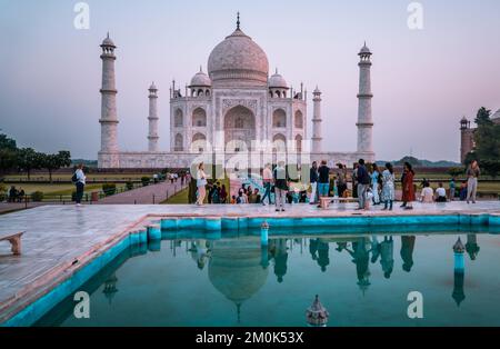 Eine Gruppe von Leuten im Taj Mahal bei Sonnenaufgang in Agra, Indien Stockfoto