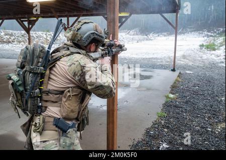 Ein Green Beret mit 1. Special Forces Group (Airborne) greift ein Ziel während des Menton 2022 Best Sniper Competition auf der Joint Base Lewis-McChord, Washington, am 5. Dezember 2022 an. Der Wettbewerb besteht aus neun Teams, darunter ein Team des 4.. Bataillons der britischen Armee, Ranger Regiment. Während des Wettbewerbs werden bei Teamveranstaltungen präzise Schießübungen, bewegliche Ziele, scharfe Stängel und Stressschüsse bei Tageslicht und zu Stunden mit eingeschränkter Sicht durchgeführt. Während der Veranstaltung verwenden die Teilnehmer das M24 Sniper Weapon System, 5,56 M4 Carbine und 9mm Pistole. (USA Armeefoto von Sergeant Tho Stockfoto