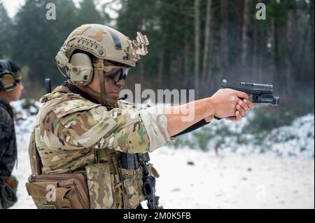 Ein Green Beret mit 1. Special Forces Group (Airborne) greift ein Ziel während des Menton 2022 Best Sniper Competition auf der Joint Base Lewis-McChord, Washington, am 5. Dezember 2022 an. Der Wettbewerb besteht aus neun Teams, darunter ein Team des 4.. Bataillons der britischen Armee, Ranger Regiment. Während des Wettbewerbs werden bei Teamveranstaltungen präzise Schießübungen, bewegliche Ziele, scharfe Stängel und Stressschüsse bei Tageslicht und zu Stunden mit eingeschränkter Sicht durchgeführt. Während der Veranstaltung verwenden die Teilnehmer das M24 Sniper Weapon System, 5,56 M4 Carbine und 9mm Pistole. (USA Armeefoto von Sergeant Tho Stockfoto