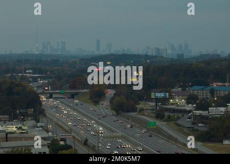 American Freeway mit schnell fahrenden Autos und Lastwagen und Hochhäusern von Atlanta City im Bundesstaat Georgia. Blick von oben auf den Transport der USA Stockfoto