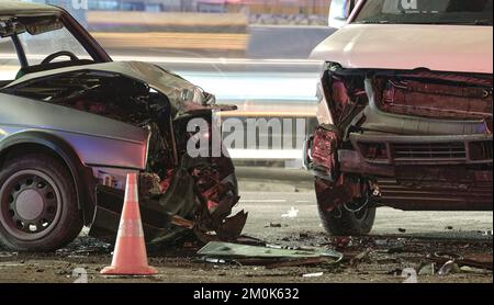 Autos stürzten bei einem Verkehrsunfall nach einem Zusammenstoß auf der Straße der Stadt in der Nacht stark ab. Straßenverkehrssicherheit und Versicherungskonzept Stockfoto