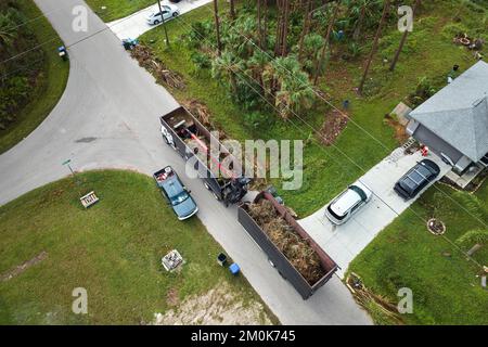 Draufsicht auf den besonderen Nachwirkungen des Unwehen-Rückgewinnungs-Muldenkipper des Unwrts, der Baumzweige aus ländlichen Straßen Floridas aufsammelt. Umgang mit Konsequenzen Stockfoto