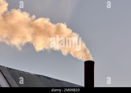 Rauch kommt aus dem Schornstein der Bourgeoisie, der Ofen wird erhitzt. Stockfoto