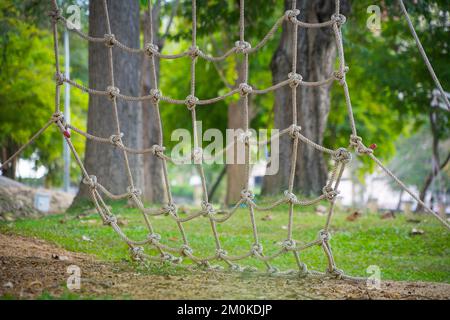 Klettern Sie ein Netz Nahaufnahme Klettern Sie das Netz, wählen Sie Fokus Grüner Naturhintergrund. Stockfoto