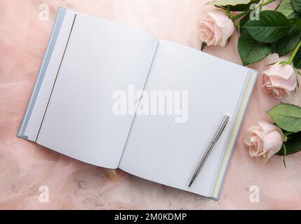 Flach liegender Büroschreibtisch für Frauen. Weiblicher Arbeitsplatz mit pinkfarbenem Blumenstrauß, Milchprodukte, Gläser Stockfoto