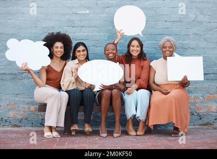 Gruppe von fünf verschiedenen jungen, fröhlichen Geschäftsfrauen, die draußen in der Stadt auf einer Bank an einer Wand sitzen und Sprechblasen halten. Geschäftsleute Stockfoto