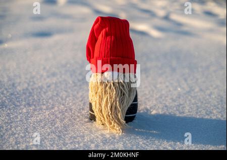 Handgemachter Weihnachtszwerg auf Schnee. Upcycle, aus alten Socken. Komposition der Mitte Stockfoto