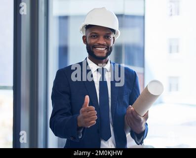 Daumen hoch, glücklicher Ingenieur oder Architekt, schwarzer Mann mit dem Ziel oder Plan für den Erfolg des Baugewerbes. Unterstützung, Dankeschön oder Bauarbeiter mit einem Lächeln Stockfoto