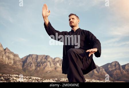 Tai Chi, Kampfsport und Fitness im Freien, man macht Karate- und Sportmotivation, Körpertraining und Wellness. Sport am Strand mit Achtsamkeit und Stockfoto