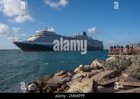 Adelaide, Australien. 7. Dezember 2022 Besucher, die das Luxusschiff RMS Queen Elizabeth sehen, wenn es nach einem kurzen Aufenthalt am Sommerabend vom Passagierterminal Flinders Ports in Adelaide ablegt. Das Schiff Queen Elizabeth, das nach Bali fuhr, wurde nach Fremantle, Westaustralien, umgeleitet, nachdem letzte Woche ein Covid-Ausbruch an Bord aufgetreten war. Kredit: amer Ghazzal/Alamy Live News Stockfoto