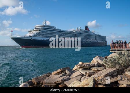 Adelaide, Australien. 7. Dezember 2022 Besucher, die das Luxusschiff RMS Queen Elizabeth sehen, wenn es nach einem kurzen Aufenthalt am Sommerabend vom Passagierterminal Flinders Ports in Adelaide ablegt. Das Schiff Queen Elizabeth, das nach Bali fuhr, wurde nach Fremantle, Westaustralien, umgeleitet, nachdem letzte Woche ein Covid-Ausbruch an Bord aufgetreten war. Kredit: amer Ghazzal/Alamy Live News Stockfoto