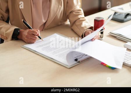 Unternehmerin unterschreibt Vertrag auf dem Schreibtisch Stockfoto