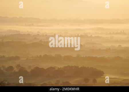 Die Sonne geht über einem nebligen Worcestershire auf, von den Malvern Hills aus gesehen. Das Vereinigte Königreich bereitet sich auf ein Eisklima vor, da Wettervorhersagen sagen sagen, dass die arktische Luft ab Mittwochabend einziehen wird, wobei die britische Gesundheits- und Sicherheitsbehörde einen Kältealarm ausgibt, der den Menschen empfiehlt, ihre Häuser auf mindestens 18C °C zu wärmen (64,4F). Bilddatum: Mittwoch, 7. Dezember 2022. Stockfoto