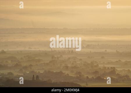 Die Sonne geht über einem nebligen Worcestershire auf, von den Malvern Hills aus gesehen. Das Vereinigte Königreich bereitet sich auf ein Eisklima vor, da Wettervorhersagen sagen sagen, dass die arktische Luft ab Mittwochabend einziehen wird, wobei die britische Gesundheits- und Sicherheitsbehörde einen Kältealarm ausgibt, der den Menschen empfiehlt, ihre Häuser auf mindestens 18C °C zu wärmen (64,4F). Bilddatum: Mittwoch, 7. Dezember 2022. Stockfoto