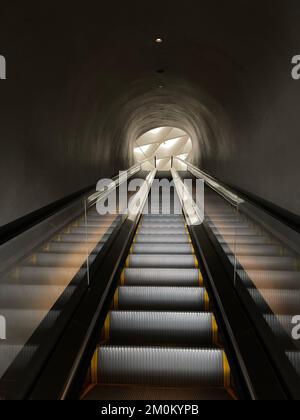 Eine Rolltreppe, die zum Ende des Tunnels führt Stockfoto