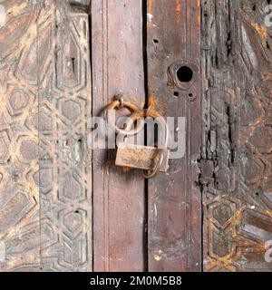 Alte Holztür im arabischen Stil mit rostigem Vorhängeschloss Stockfoto