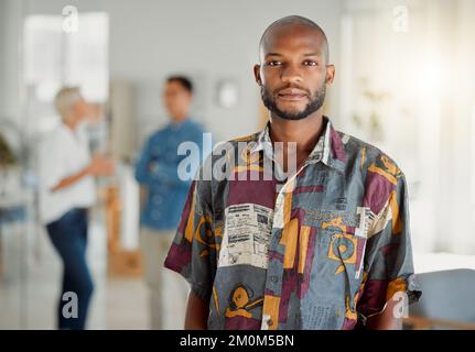 Porträt eines jungen afroamerikanischen Geschäftsmanns, der in einem Büro bei der Arbeit steht. Männlicher Geschäftsmann, der in einem Büro auf der Arbeit steht. Fokussiertes Geschäft Stockfoto