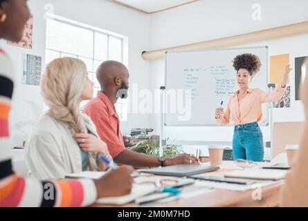 Eine Gruppe vielseitiger Geschäftsleute, die in einem modernen Büro eine Besprechung abhalten. Junge hispanische Geschäftsfrau, die während einer Präsentation eines spricht Stockfoto