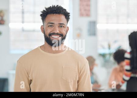 Porträt eines fröhlichen Geschäftsmanns gemischter Rassen, der in einem Büro steht. Porträtfoto eines selbstbewussten hispanischen Managers, der lächelt und bei der Arbeit steht Stockfoto