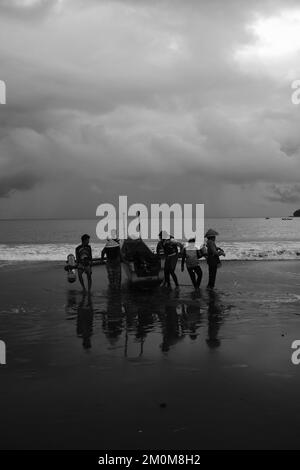 Pangandaran, West Java, Indonesien - 30. Oktober 2022 : Schwarzweißfoto, Schwarzweißfoto von Fischern, die auf einem Boot Fische fangen Stockfoto