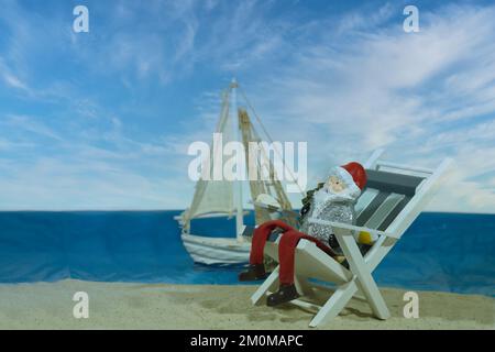 Ein Weihnachtsmann-Spielzeug, das auf einem Liegestuhl sitzt Stockfoto