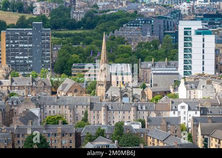 Einzigartiger Turm, umgeben von Wohngebäuden und Gärten. Sommerwetter, grüne Bäume und turmgeschützte Apartmentblöcke. Stockfoto