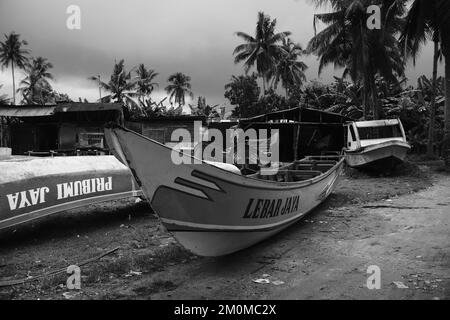 Pangandaran, West Java, Indonesien - 30. Oktober 2022 : Schwarzweißfoto, Schwarzweißfoto eines Fischerboots an der Küste verkehrt herum Stockfoto
