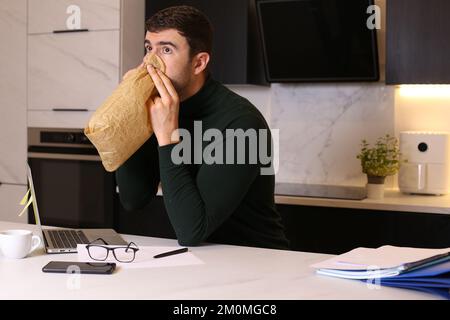 Ein Mann hat einen Nervenzusammenbruch, während er von zu Hause aus arbeitet Stockfoto