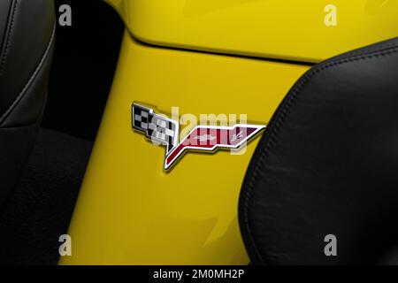 Eine Nahaufnahme der Chevrolet Corvette C6 Grand Sport Ikone zwischen den Sitzen, Corvette Logo auf einem gelben Feld. Stockfoto