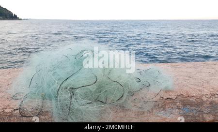 Das Fischernetz, das sich im Hintergrund mit dem See verheddert Stockfoto
