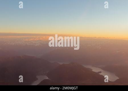 Blick aus der Vogelperspektive auf den Comer See, den Ceresio See und die Alpen im rosa und warmen Licht des Sonnenaufgangs (mit Halbinsel Bellagio, Porlezza, Halbinsel Lenno) Stockfoto