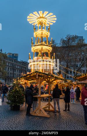 Eine vertikale Aufnahme einer Weihnachtspyramide auf dem „Rossmarkt“-Weihnachtsmarkt am Abend in Frankfurt Stockfoto